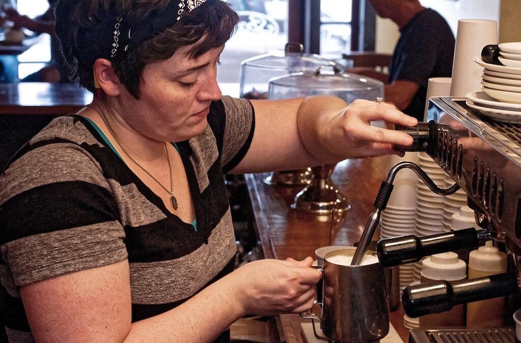photo of woman pouring a pitcher of espresso