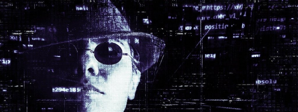 photo of man in a hat and sunglasses in front of a clear screen of data